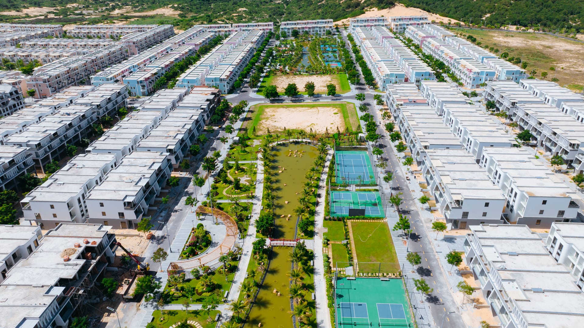 Công viên nội khu ParaSol Cam Ranh nhìn từ trên cao — sân tennis, hồ bơi, cây xanh giữa lòng khu đô thị